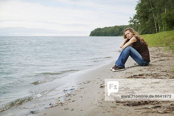 Young Woman Sitting On A Beach