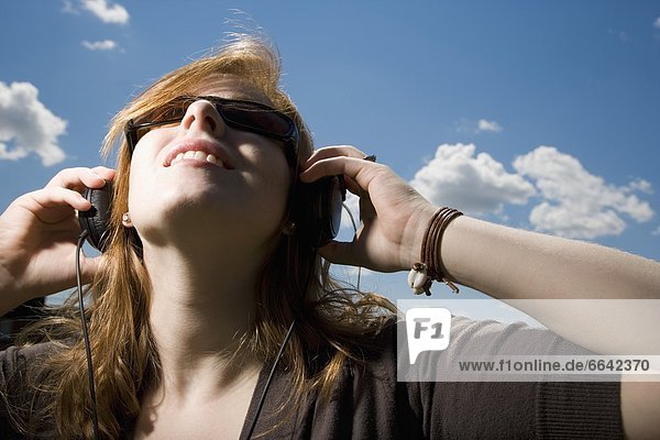 Woman With Sunglasses And Earphones