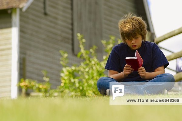 Boy Reading A Book Outside
