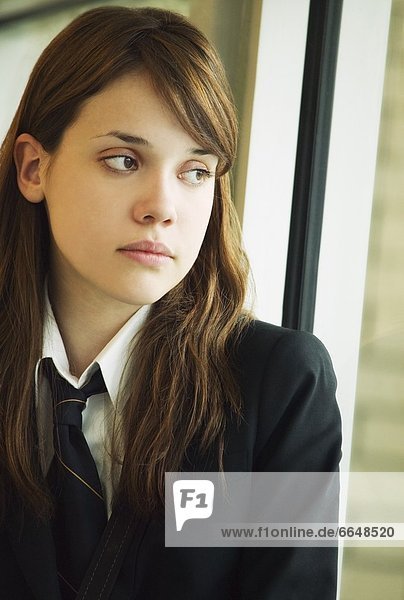 A Student In Uniform Looking Out A Window