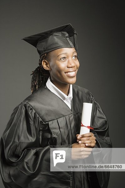 Young Woman In Cap And Gown With Diploma