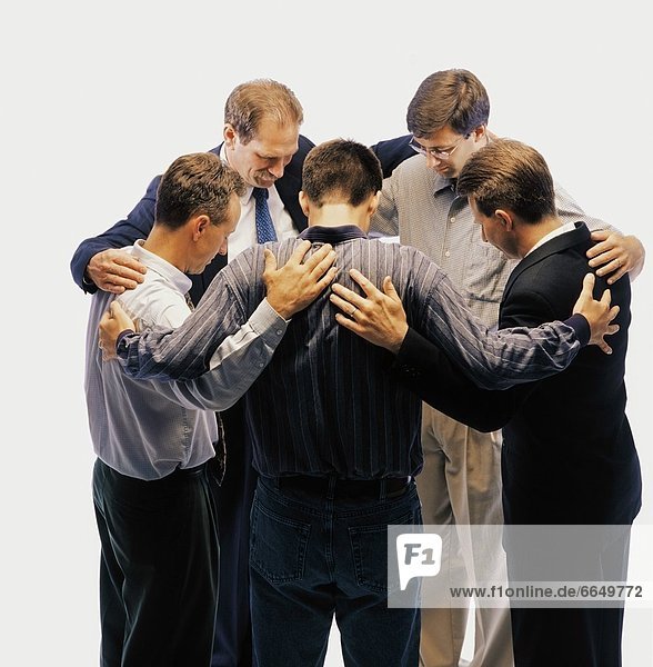 Group Of Men Standing In A Circle And Praying