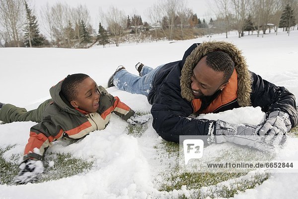 Menschlicher Vater Sohn spielen Schnee