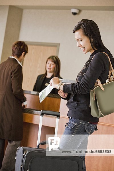 Woman Checking Time In Hotel Lobby