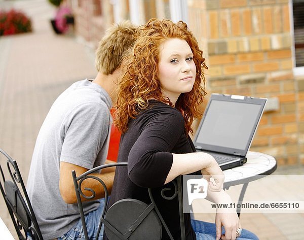 Couple Working On Laptop Outside