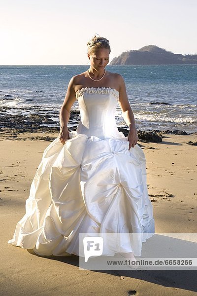 Woman In Wedding Dress On Beach