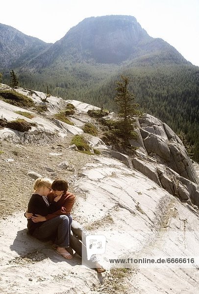 Couple Sitting On The Edge In Jasper  Alberta  Canada