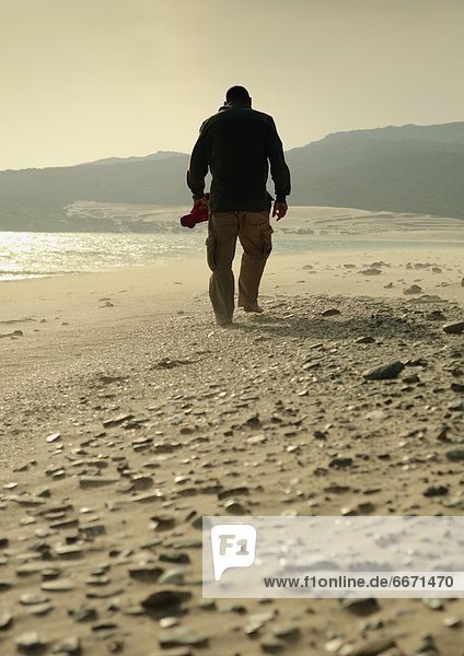 Man Walking On A Rocky Beach