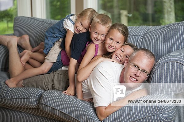 Children With Father Lying On Couch