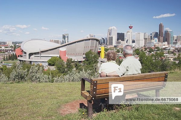 Elderly Couple Sitting On A Bench Overlooking The Saddledome  Calgary  Alberta  Canada