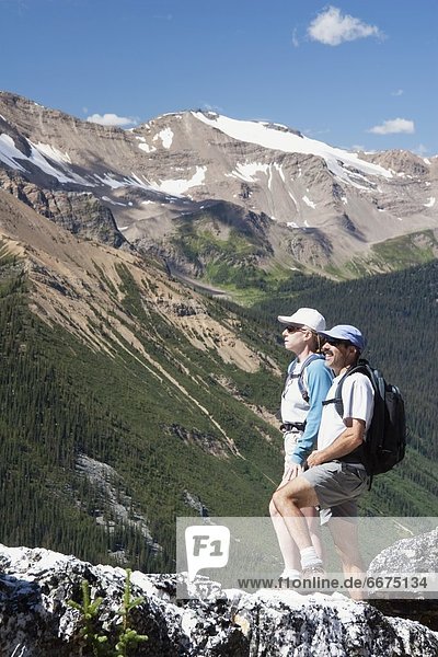 Couple Standing On The Top Of A Mountain