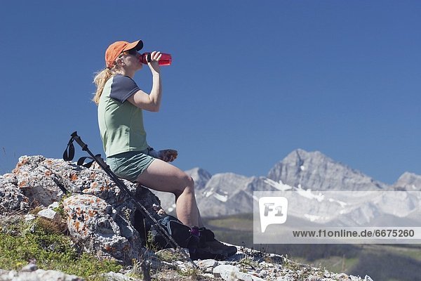 Felsbrocken sitzend Wasser wandern trinken Flasche