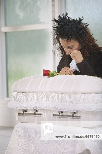 Young Mother Grieving At An Infant's Coffin