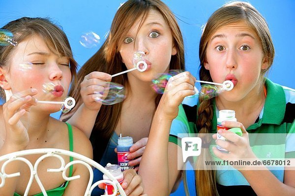 Three Friends Blowing Bubbles