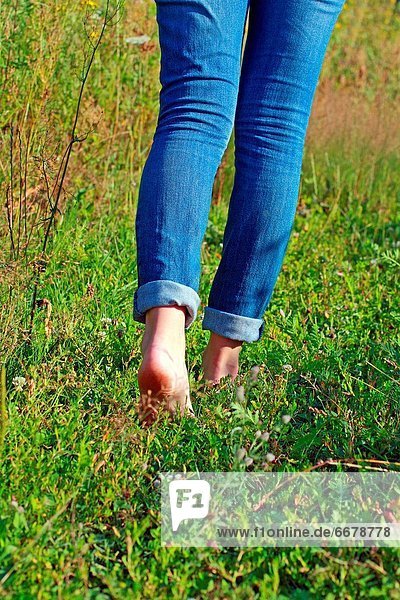 Frau gehen blau barfüßig Jeans Gras