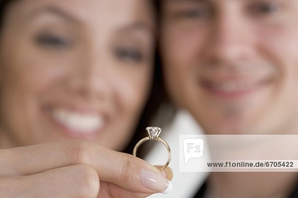 Closeup of ring and admiring couple