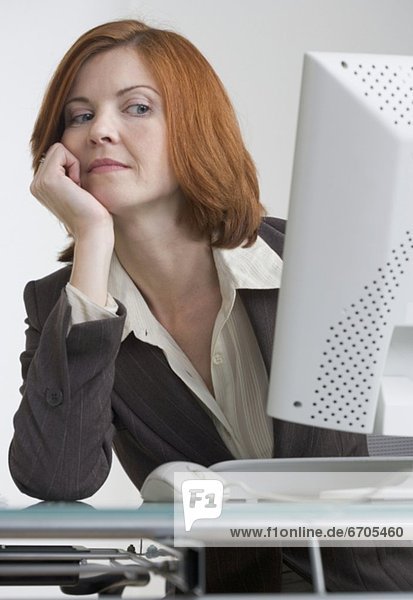 Businesswoman looking askance at her computer