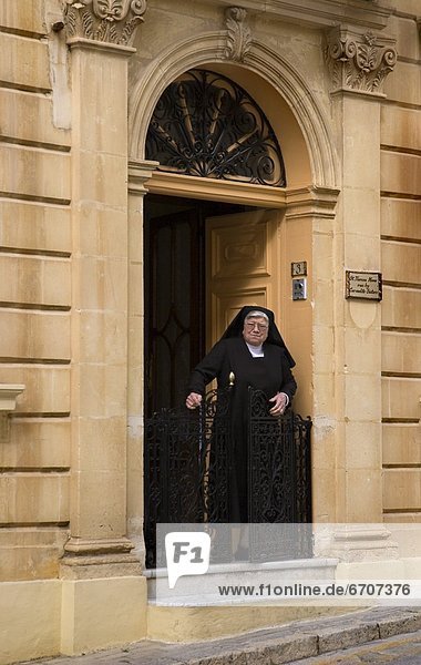 Elderly Nun In Exterior Doorway