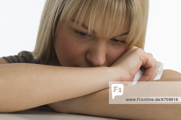 Sad woman with chin resting on her arms