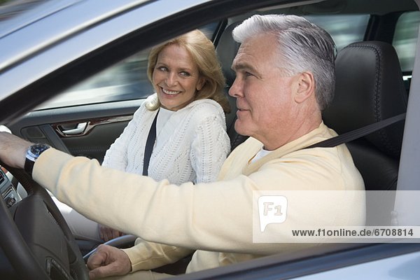 Senior couple driving in car