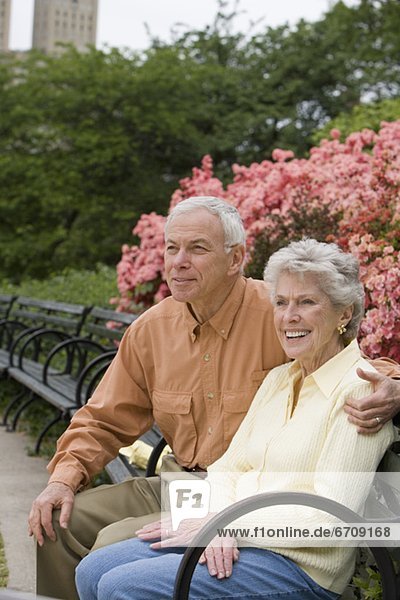Seniorenpaar sitzt auf Parkbank