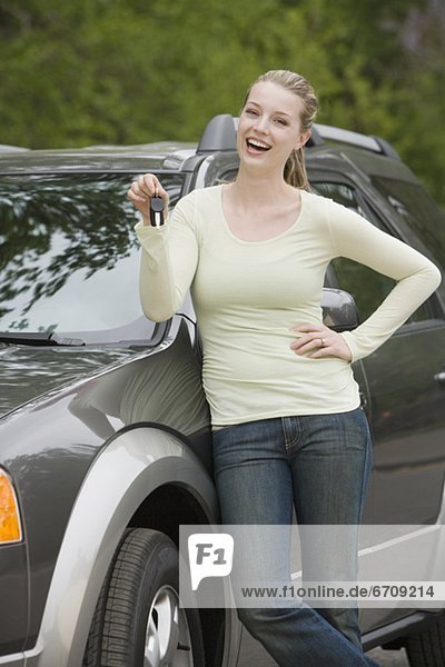Young woman standing with her new car