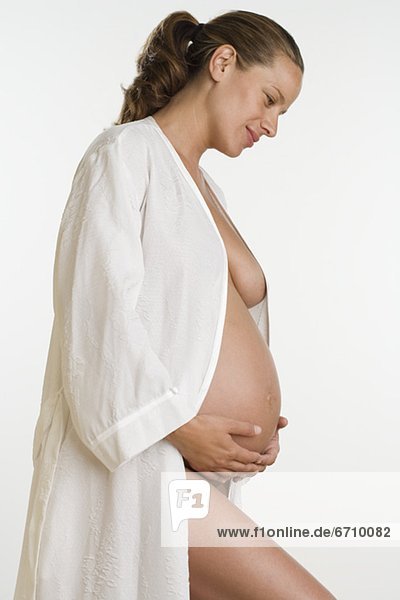 Studio shot of semi-nude pregnant woman in bathrobe