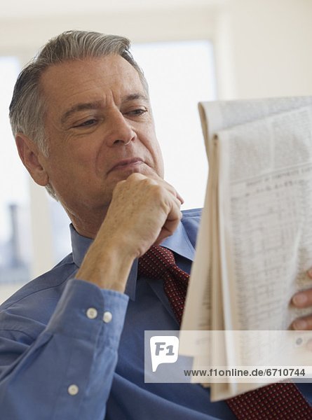 Senior businessman reading newspaper