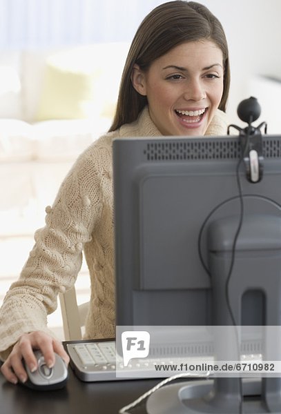 Woman smiling at webcam on computer