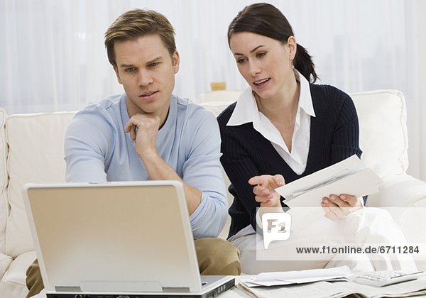Couple paying bills on laptop