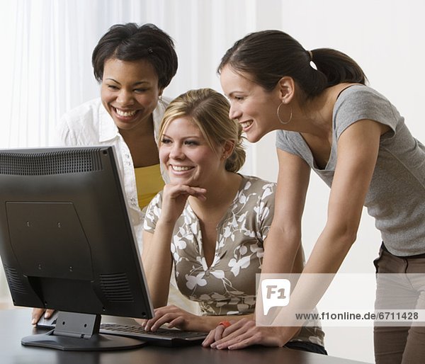 Multi-ethnic women looking at computer