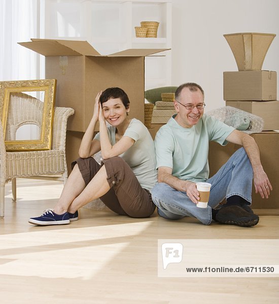 Couple on floor next to moving boxes