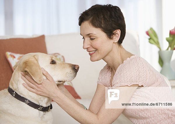 Woman petting dog in livingroom