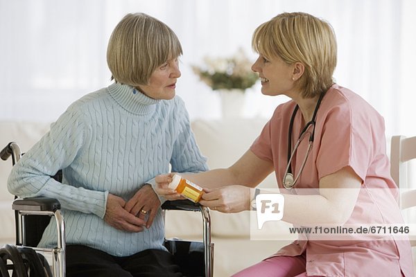 Nurse discussing medication with senior woman