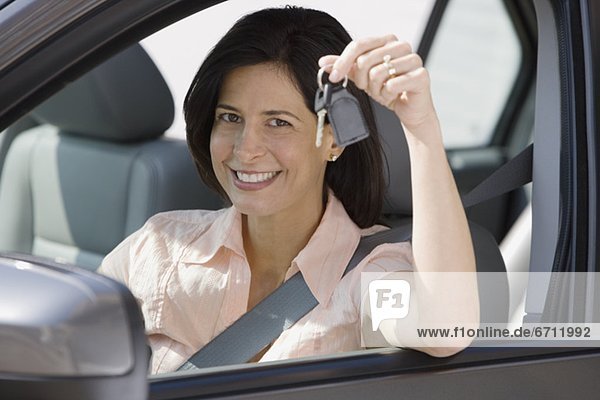 Woman holding car keys in car