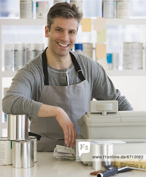 Male clerk at counter of paint store