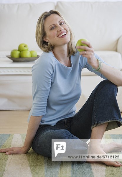 Woman holding apple on floor