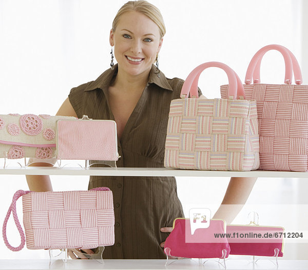 Woman behind shelves of purses