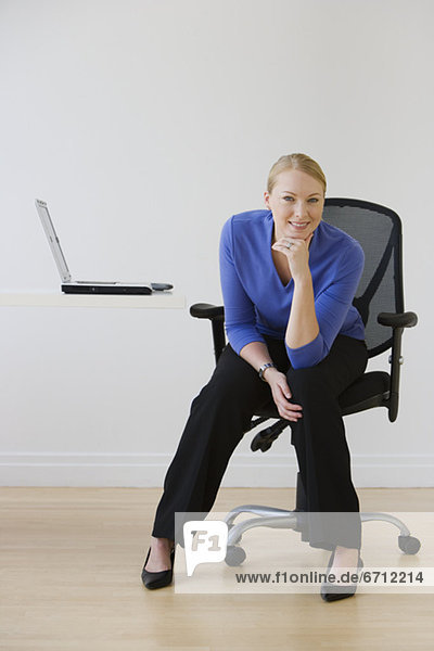 Businesswoman sitting next to laptop