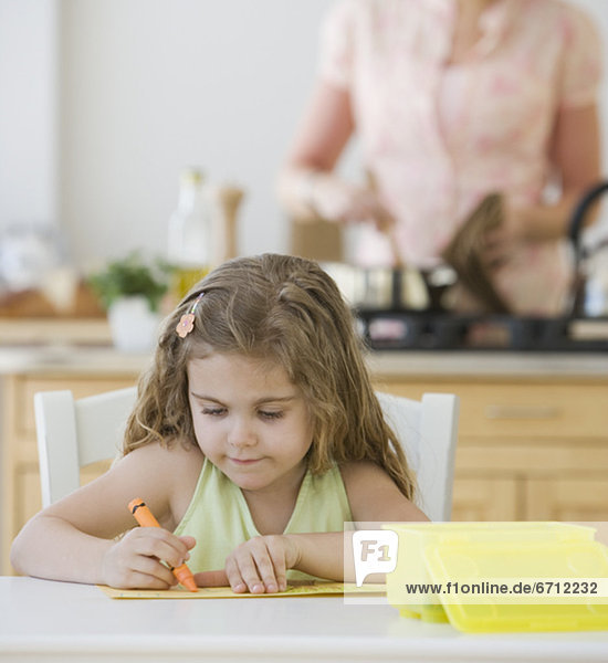 Girl coloring at kitchen table