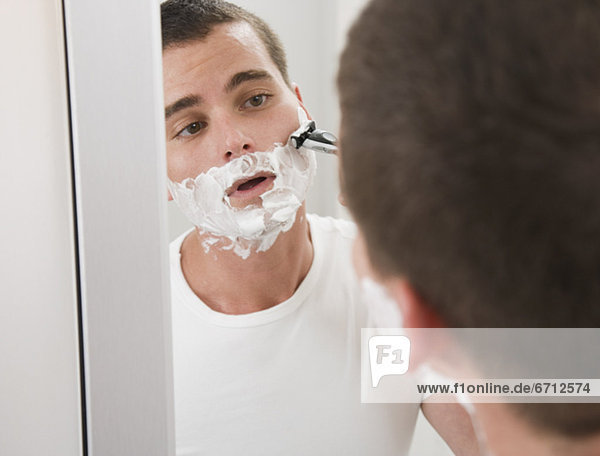Mann rasieren in Spiegel