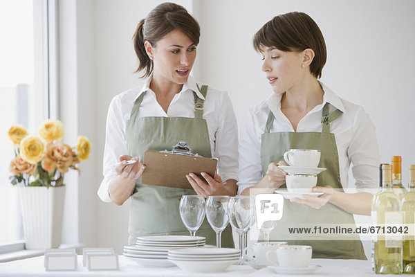 Two female caterers with dishware