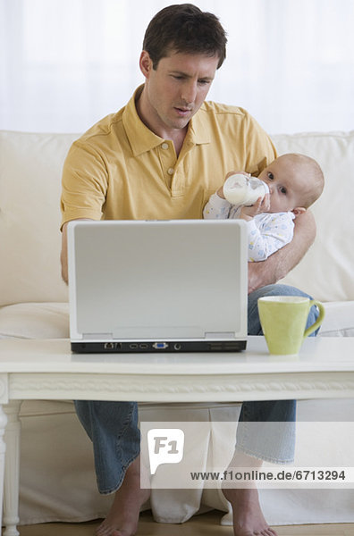 benutzen  Notebook  Menschlicher Vater  Baby  füttern