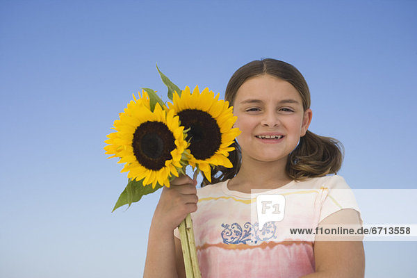 Mädchen hält Sonnenblumen