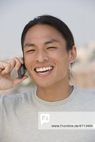 Asian man talking on cell phone