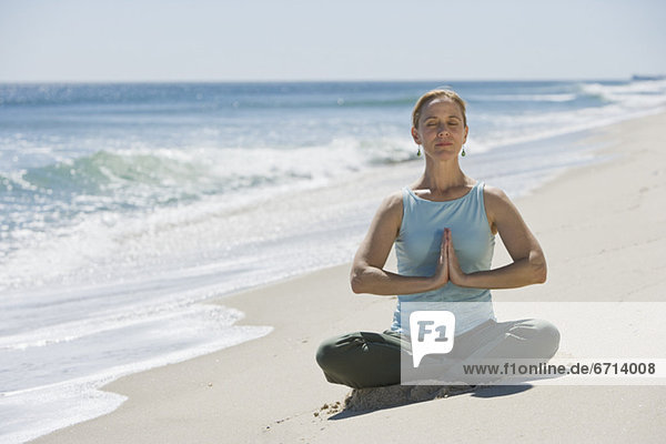 Frau meditating at beach