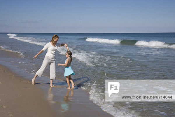 Mother and daughter dancing at beach