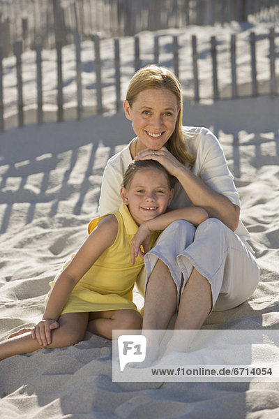 Mutter und Tochter sitzt am Strand