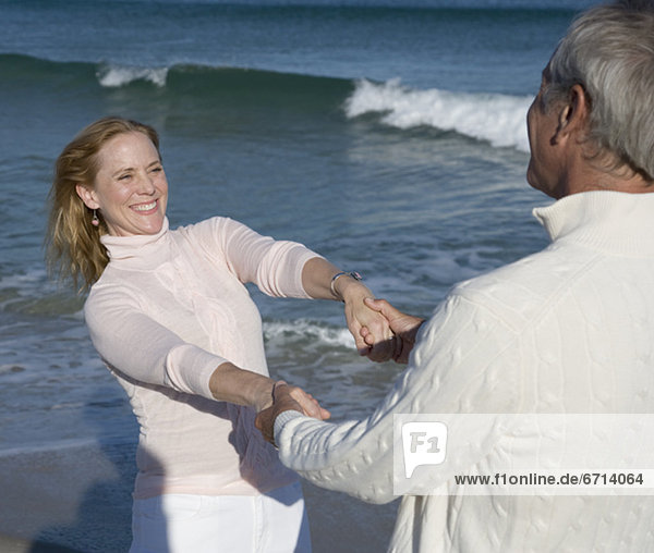 Paar hält hände am Strand