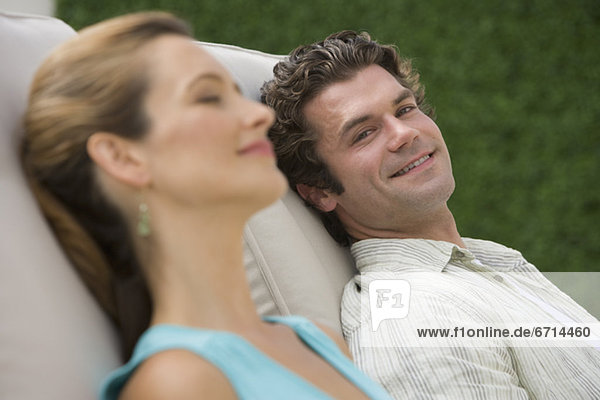 Couple laying in lounge chairs